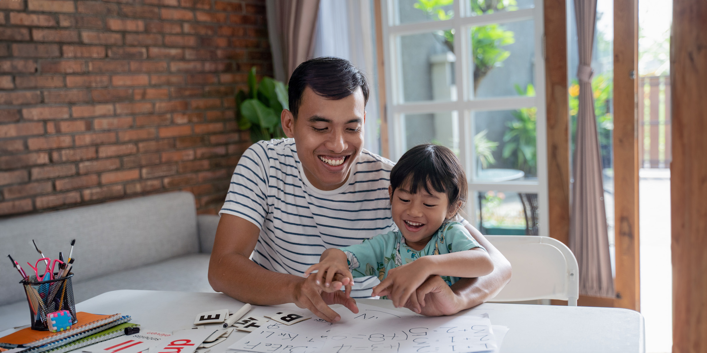 toddler studying with her father at home