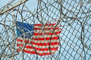 American flag behind barbed wire fence