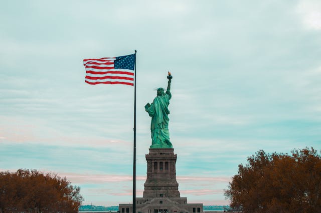 statue of liberty and american flag