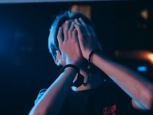 person with hands covering face